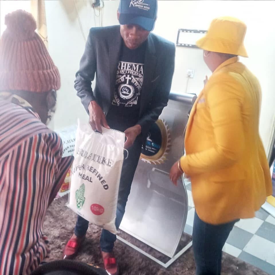 Apostle Keith distributing mealie meal bags